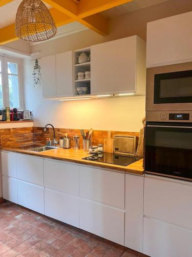 une cuisine avec un évier et un micro-ondes dans l'établissement Maison de pêcheur Loguivy de la mer pour 7 personnes, à Ploubazlanec