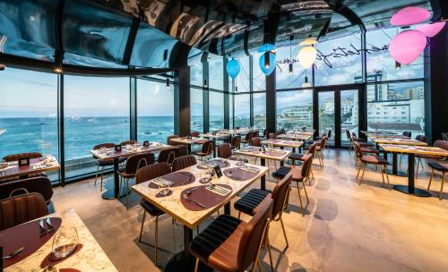 a restaurant with tables and chairs and a view of the ocean at Silken Saaj Maar - Adults Only in Puerto de la Cruz