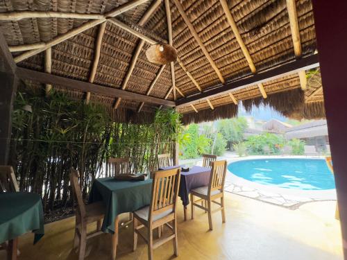 a dining room with a table and chairs and a swimming pool at Pousada North Shore Maresias - 2 quadras da praia - Casas de 2 quartos - 80 m2 -2 banheiros -piscina sauna - estacion-churrasq privativa -wifi animais de peq porte roupa de cama e banho in Maresias