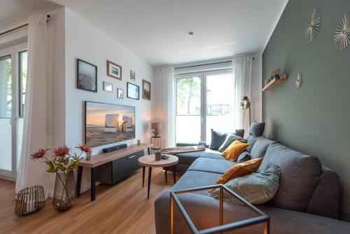 a living room with a blue couch and a tv at Ferienwohnung "Haffhafen" Hunde willkommen in Zirchow