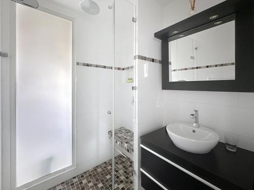 une salle de bain blanche avec un lavabo et un miroir dans l'établissement One bedroom apartment on La Croisette - Sea view, à Cannes