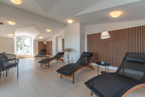 a waiting area with chairs and tables in a room at Ferienwohnung "Haffhafen" Hunde willkommen in Zirchow