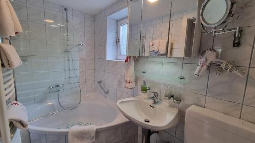a white bathroom with a sink and a shower at Landhaus Osborne near Hallstatt in Obertraun
