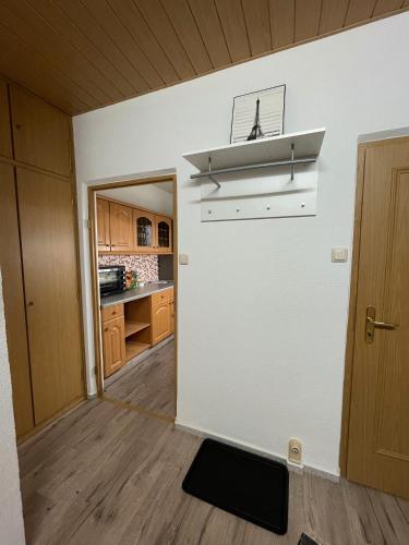 a kitchen with white walls and wooden floors and a stove at Ruhige Ferienwohnung Zeithain in Zeithain