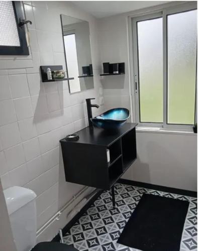 une salle de bain avec un lavabo noir et des toilettes dans l'établissement Appartement confortable à Hourtin avec terrasse, à Hourtin