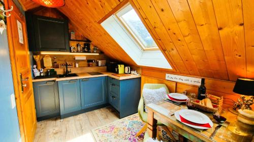 a kitchen with blue cabinets and a table and a window at Landhaus Osborne near Hallstatt in Obertraun