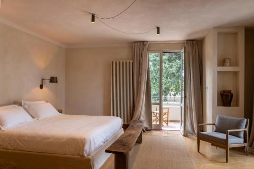 SantʼAndrea in CasaleにあるVilla Yeppaのベッドと椅子と窓のある寝室