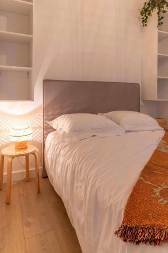 - un lit avec une tête de lit en métal dans une chambre dans l'établissement Thomas Price Appart, à Narbonne