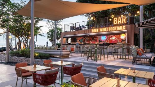 an outdoor patio with tables and chairs and a bar at Holiday Inn Pattaya by IHG in Pattaya Central