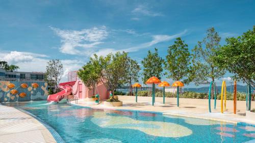 a pool at a resort with a water slide at Holiday Inn Pattaya by IHG in Pattaya Central
