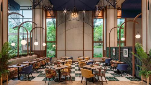 a restaurant with tables and chairs and windows at Holiday Inn Pattaya by IHG in Pattaya Central