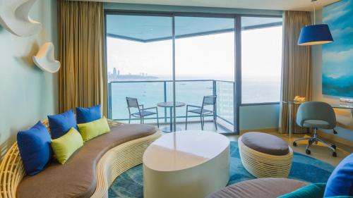 a living room with a couch and a view of the ocean at Holiday Inn Pattaya by IHG in Pattaya Central