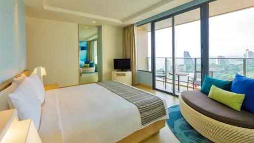 a bedroom with a large bed and a couch at Holiday Inn Pattaya by IHG in Pattaya Central