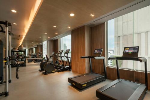 a gym with treadmills and ellipticals in a building at Holiday Inn Pattaya by IHG in Pattaya Central