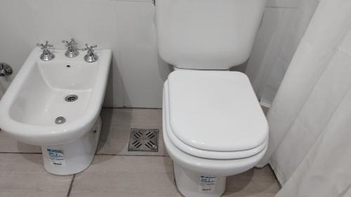 a bathroom with a white toilet and a sink at Estudio Urbano in Santa Rosa