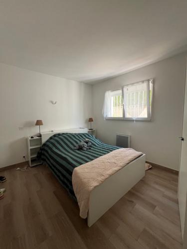 une chambre blanche avec un lit et une fenêtre dans l'établissement Spacieux T2 proche plage climatisé, à Mauguio