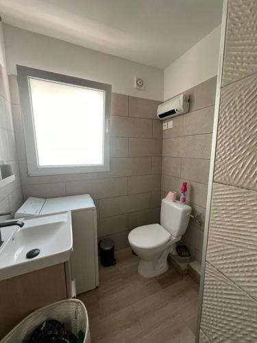 une salle de bain avec toilettes, lavabo et fenêtre dans l'établissement Spacieux T2 proche plage climatisé, à Mauguio