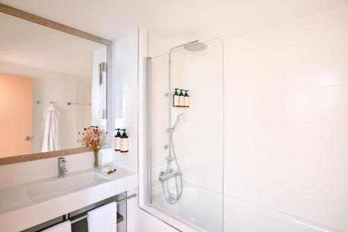 a white bathroom with a shower and a sink at Hotel Indigo Bordeaux Centre Chartrons by IHG in Bordeaux