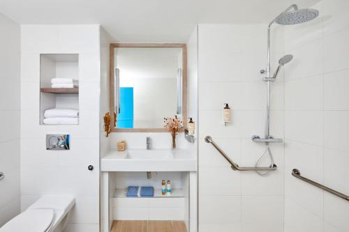 a white bathroom with a sink and a shower at Hotel Indigo Bordeaux Centre Chartrons by IHG in Bordeaux