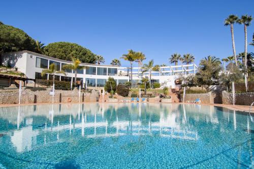 a large swimming pool in front of a building at Quinta da Floresta – Santo António Villas, Golf & Spa in Budens