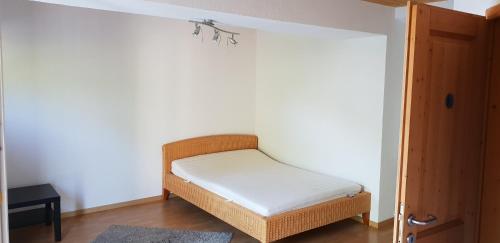 a small bed in a room with a white wall at Apartement with selfcatering in Buchs