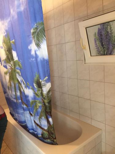 a bathroom with a shower curtain with palm trees at Apartement with selfcatering in Buchs