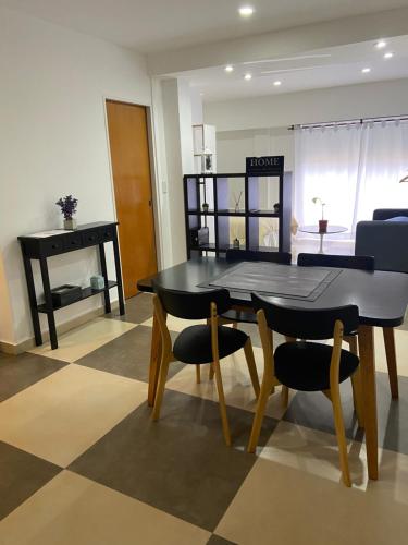 a dining room with a black table and chairs at Apart Duclout Monte Grande a 15 minutos del Aeropuerto Ezeiza in Monte Grande