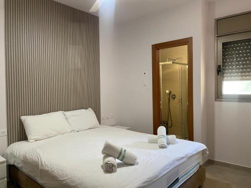 Un dormitorio con una cama con dos toallas encima. en Amdar 2BR Garden Apt EILAT, en Eilat