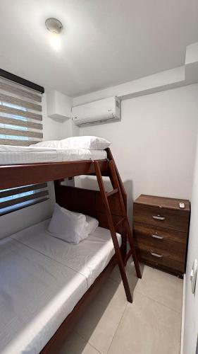 a small room with two bunk beds and a nightstand at Extraordinario apartamento con BBQ in Ricaurte
