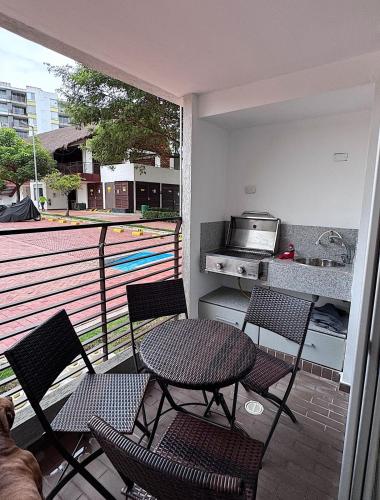 a patio with a table and chairs and a kitchen at Extraordinario apartamento con BBQ in Ricaurte