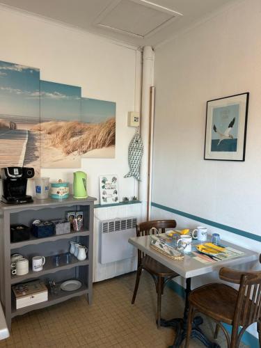 Una cocina con una mesa y sillas en una habitación. en Hôtel La Coursive, en Saint-Pierre-dʼOléron