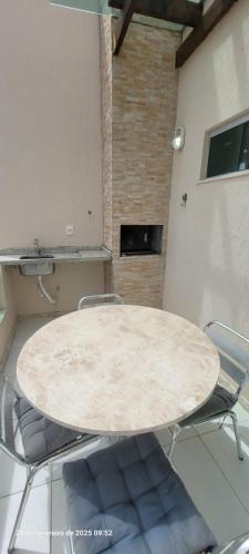 einen Marmortisch mit Stühlen im Zimmer in der Unterkunft Casa 3 quartos 2 suítes na praia a 2km da Atalaia in Aracaju