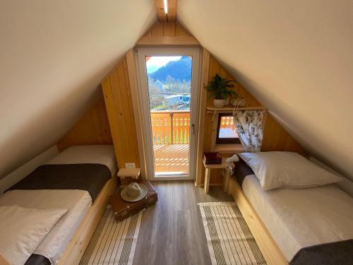 a attic room with two beds and a window at Princess Mojca Holiday House in Bled