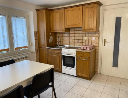 a kitchen with wooden cabinets and a white stove top oven at Apartma Savan in Tolmin