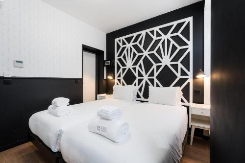 a bedroom with a large white bed with towels on it at The Twenties by GuestReady in Lisbon