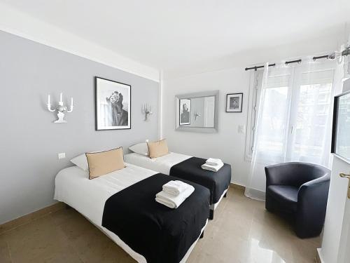 - une chambre avec 2 lits et une chaise dans l'établissement Two en-suite bedroom apartment on La Croisette - Sea view, à Cannes