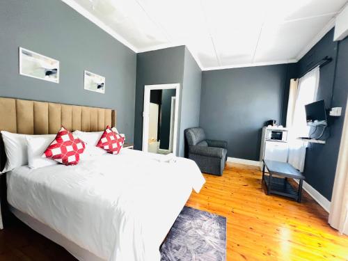 a bedroom with a large bed and a chair at Alberta Bed and Breakfast in Pietermaritzburg