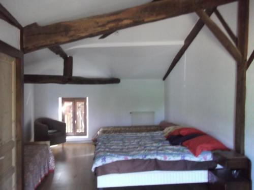 a bedroom with a bed in a room with wooden beams at Gite Tauzia in Brassempouy