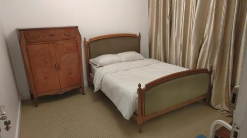 - une petite chambre avec un lit et une commode dans l'établissement Villa B, à Bobigny