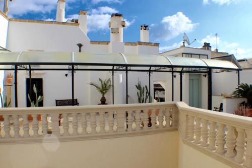 a balcony of a house with a white railing at Palazzo Senape De Pace in Gallipoli