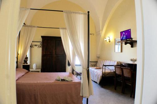 a bedroom with a canopy bed and a dining room at Palazzo Senape De Pace in Gallipoli