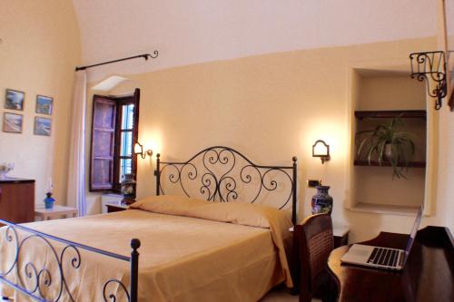 a bedroom with a bed and a laptop on a table at Palazzo Senape De Pace in Gallipoli