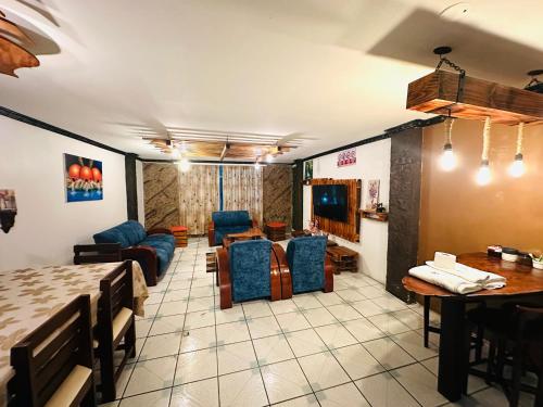 a living room with a couch and a table and chairs at Confort Home Apartamentos Vacacionales in Baños