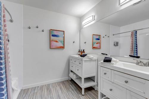 a white bathroom with a sink and a mirror at Mountain Views Climbing wall Mini Golf Hot tub in Colorado Springs