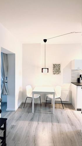 a white dining room with a white table and chairs at Suite Hilde in Neuwied