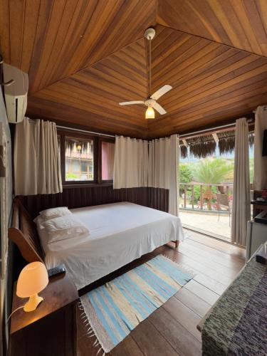 a bedroom with a bed and a ceiling fan at Condominio Pousada North Shore Maresias Studios p 2 3 e 4 pessoas 2 quadras da praia mini cozinha completa tv ar cond wifi estacionamento roupa de cama e banho in Maresias