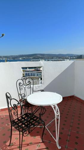 a white table and a chair on a balcony at The Medina Riad in Tangier