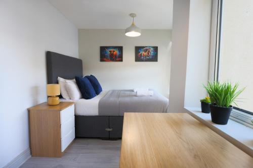 a bedroom with a bed and a wooden table at 2 Bed Home-Cheltenham-Sleeps 6-Work or Leisure in Cheltenham