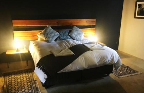 a bedroom with a large bed with a wooden headboard at Klein Karoo Game Lodge in Oudtshoorn
