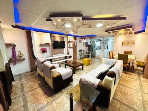 a large living room with couches and a television at Confort Home Apartamentos Vacacionales in Baños